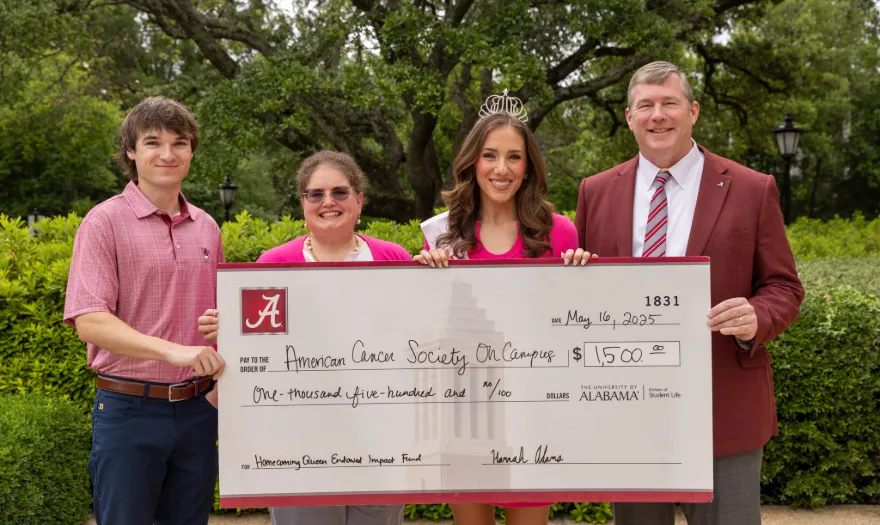 Hannah Adams, Dr. Hood and two other people holding a donation check for American Cancer Society.