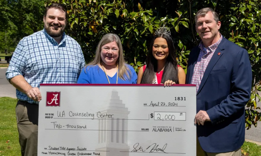 Mae Farmer, Dr. Hood and two other people holding a donation check for the UA Counseling Center.